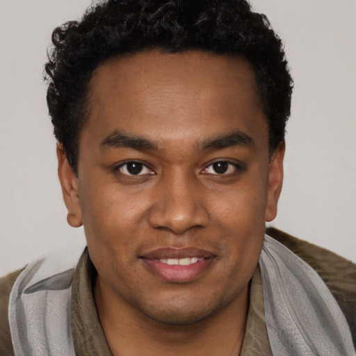 Joyful black young-adult male with short  brown hair and brown eyes