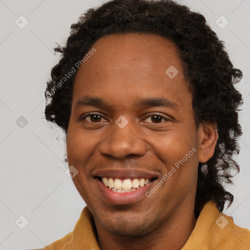 Joyful black young-adult male with short  brown hair and brown eyes