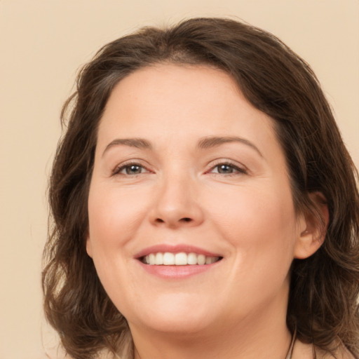 Joyful white adult female with medium  brown hair and brown eyes