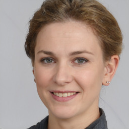 Joyful white young-adult female with medium  brown hair and grey eyes