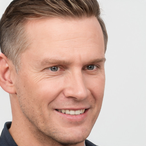 Joyful white adult male with short  brown hair and grey eyes