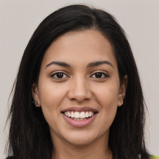 Joyful latino young-adult female with long  brown hair and brown eyes