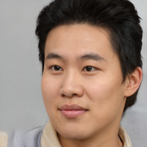 Joyful asian young-adult male with medium  brown hair and brown eyes