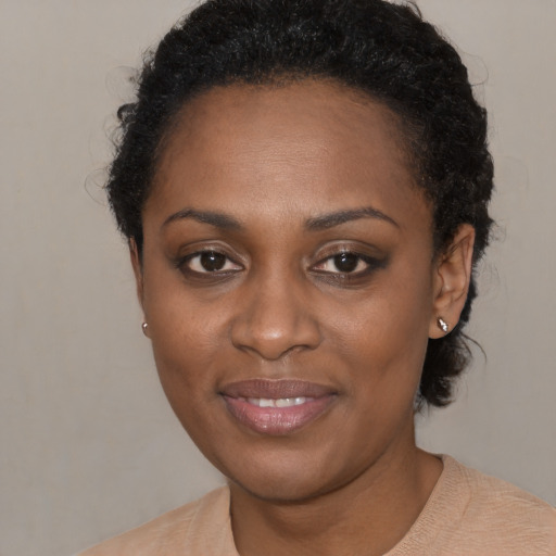 Joyful black young-adult female with short  black hair and brown eyes
