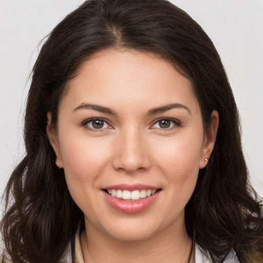 Joyful white young-adult female with long  brown hair and brown eyes