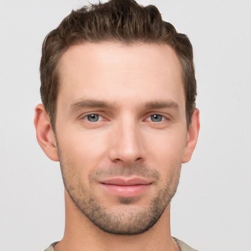 Joyful white young-adult male with short  brown hair and grey eyes