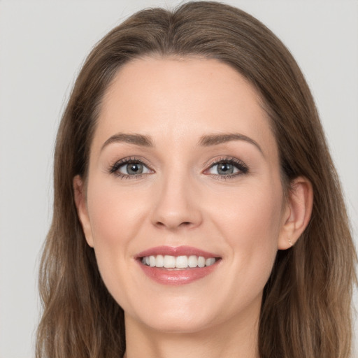 Joyful white young-adult female with long  brown hair and grey eyes