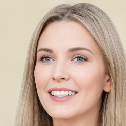 Joyful white young-adult female with long  brown hair and blue eyes