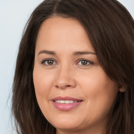 Joyful white young-adult female with long  brown hair and brown eyes