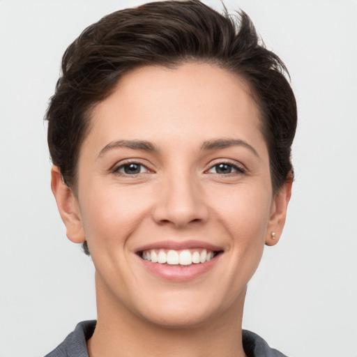 Joyful white young-adult female with short  brown hair and grey eyes