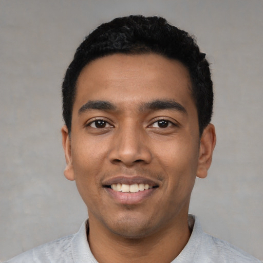 Joyful latino young-adult male with short  black hair and brown eyes