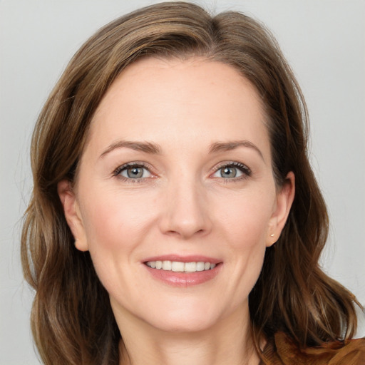 Joyful white young-adult female with medium  brown hair and grey eyes