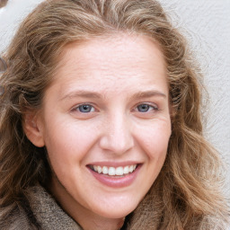 Joyful white young-adult female with long  brown hair and blue eyes