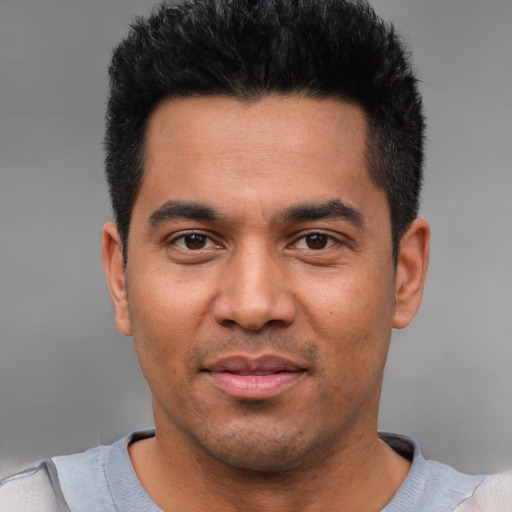 Joyful latino young-adult male with short  black hair and brown eyes
