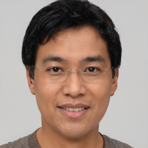 Joyful asian adult male with short  black hair and brown eyes