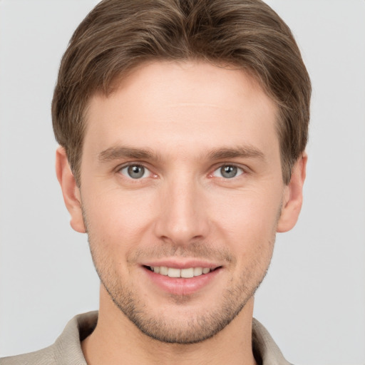 Joyful white young-adult male with short  brown hair and grey eyes