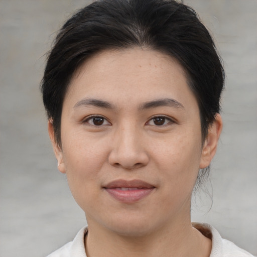 Joyful asian young-adult female with short  brown hair and brown eyes