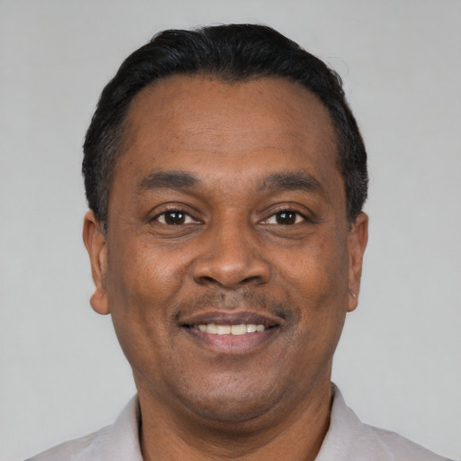 Joyful black adult male with short  black hair and brown eyes