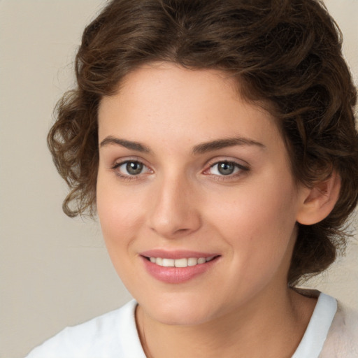 Joyful white young-adult female with medium  brown hair and green eyes