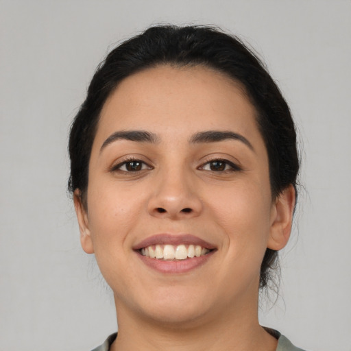 Joyful latino young-adult female with medium  black hair and brown eyes
