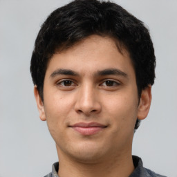 Joyful latino young-adult male with short  brown hair and brown eyes