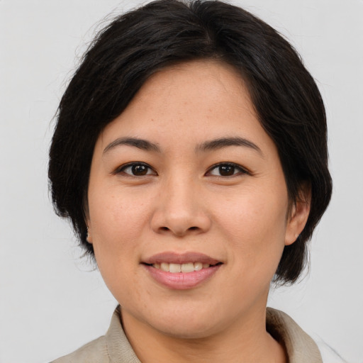 Joyful asian young-adult female with medium  brown hair and brown eyes