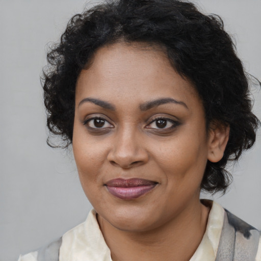 Joyful black young-adult female with medium  brown hair and brown eyes