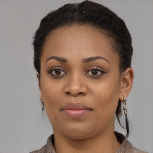 Joyful black young-adult female with short  black hair and brown eyes