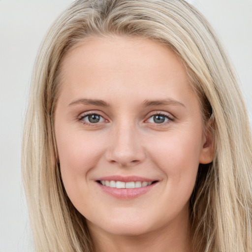 Joyful white young-adult female with long  brown hair and blue eyes