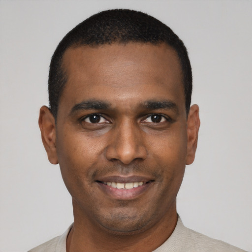 Joyful black young-adult male with short  black hair and brown eyes