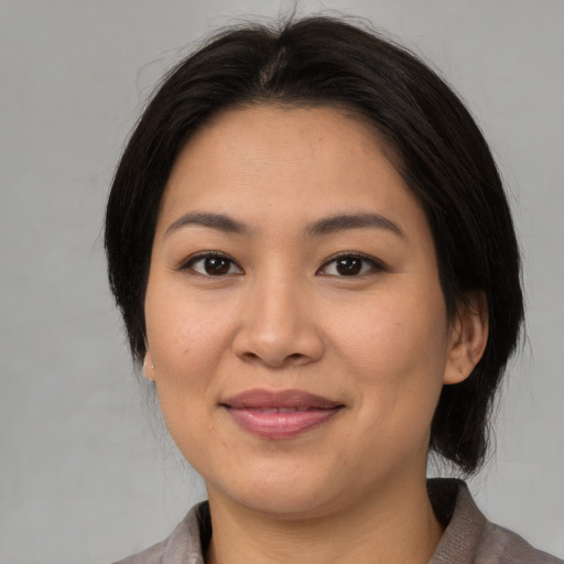 Joyful asian young-adult female with medium  brown hair and brown eyes