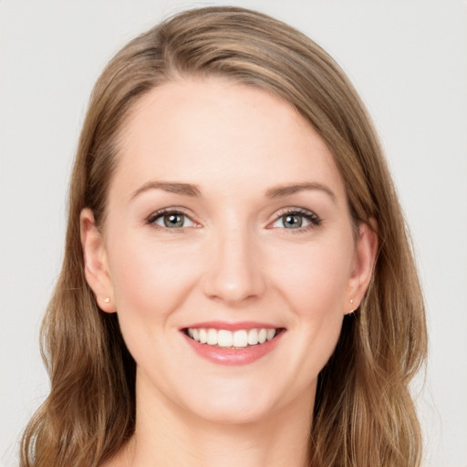 Joyful white young-adult female with long  brown hair and blue eyes