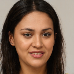 Joyful latino young-adult female with long  brown hair and brown eyes