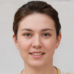 Joyful white young-adult female with short  brown hair and grey eyes