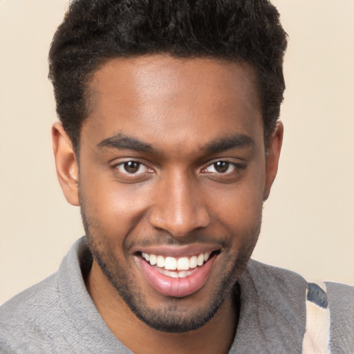 Joyful black young-adult male with short  brown hair and brown eyes