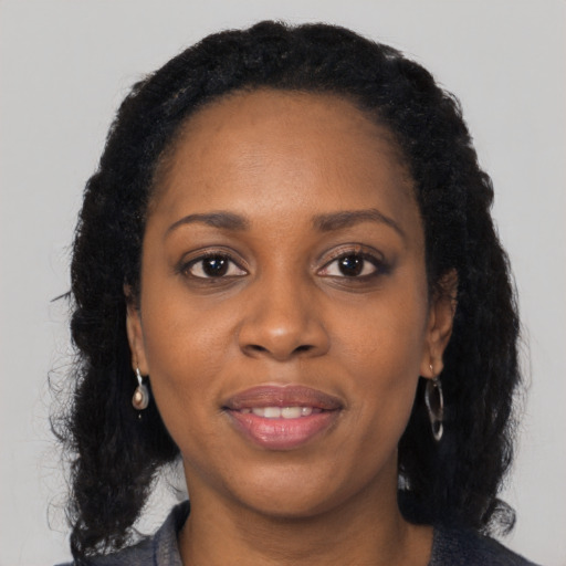 Joyful black adult female with long  black hair and brown eyes