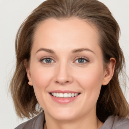 Joyful white young-adult female with long  brown hair and blue eyes