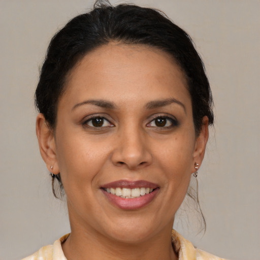 Joyful latino adult female with medium  brown hair and brown eyes