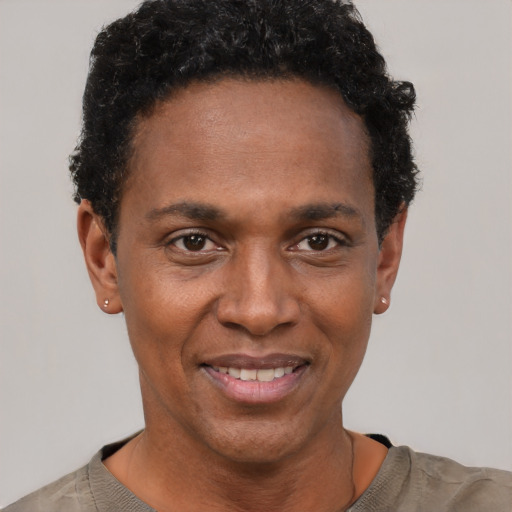 Joyful black young-adult male with short  black hair and brown eyes