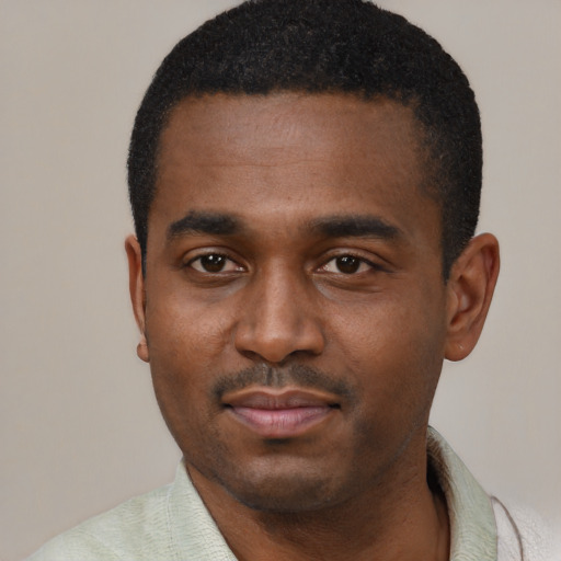 Joyful black young-adult male with short  black hair and brown eyes