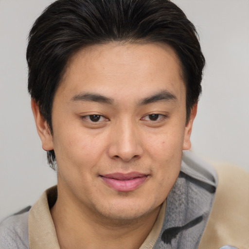 Joyful asian young-adult male with short  brown hair and brown eyes