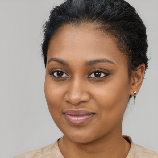 Joyful black young-adult female with short  black hair and brown eyes