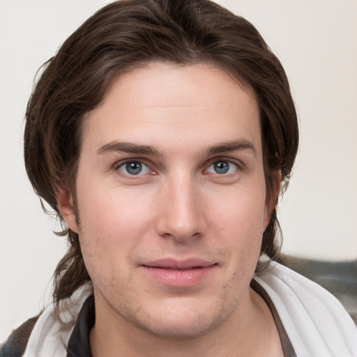 Joyful white young-adult male with medium  brown hair and grey eyes