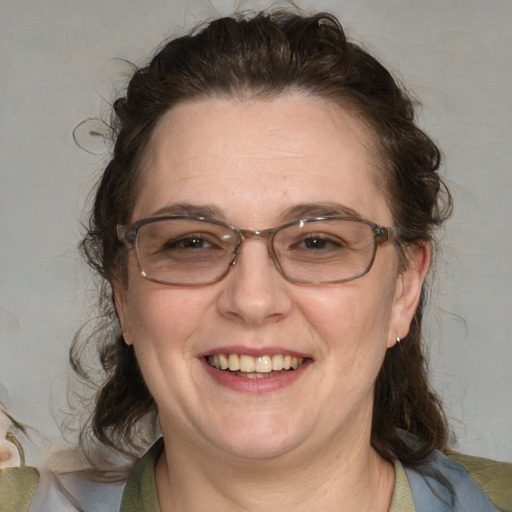 Joyful white adult female with medium  brown hair and blue eyes