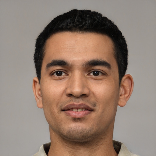 Joyful latino young-adult male with short  black hair and brown eyes