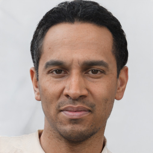 Joyful latino adult male with short  black hair and brown eyes