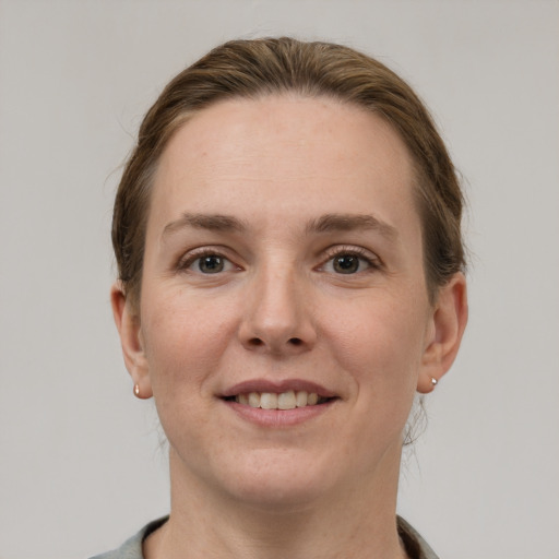 Joyful white young-adult female with short  brown hair and grey eyes