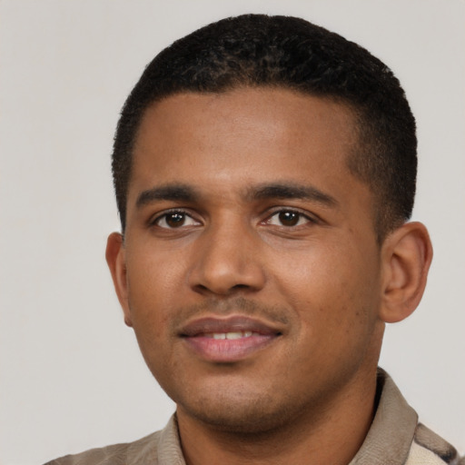 Joyful black young-adult male with short  brown hair and brown eyes