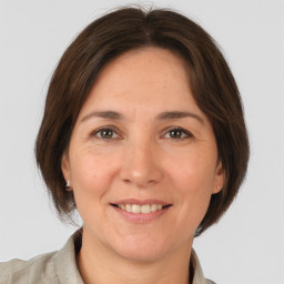 Joyful white adult female with medium  brown hair and grey eyes