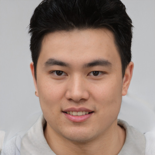 Joyful asian young-adult male with short  brown hair and brown eyes